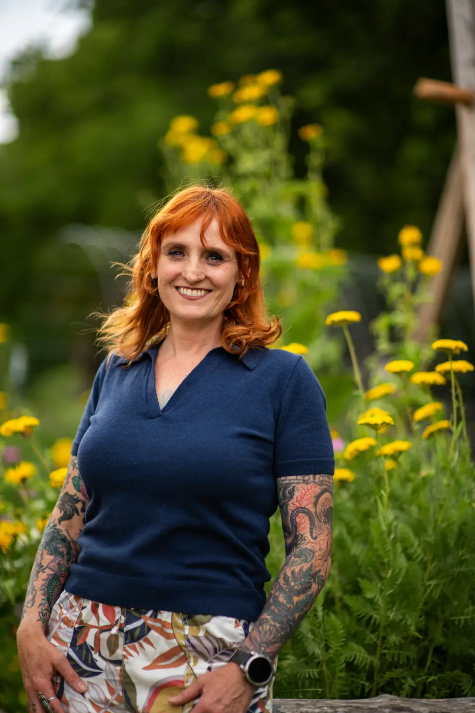 Mia Countryman smiling in a garden with yellow flowers